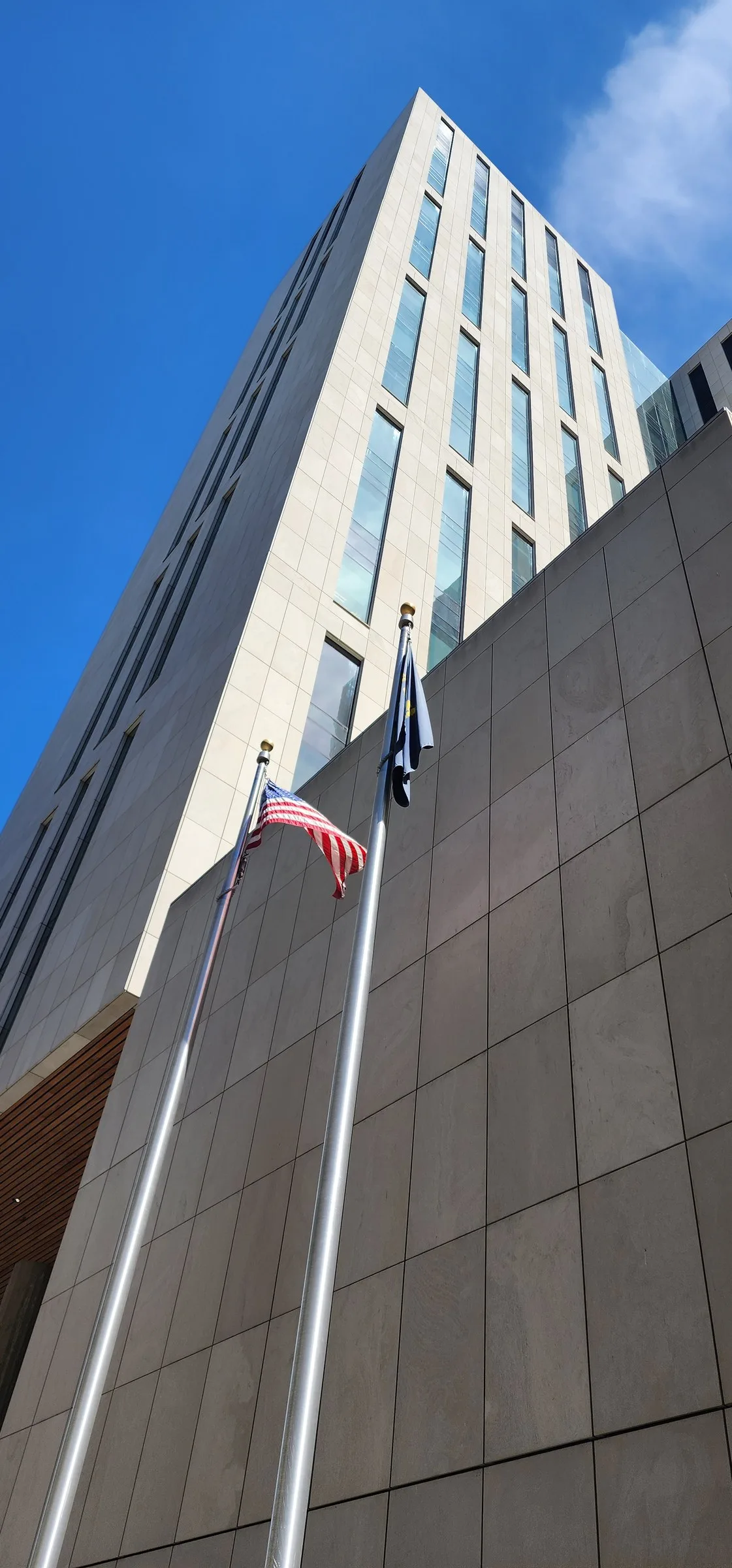 Courthouse facade with flagpoles, looking up